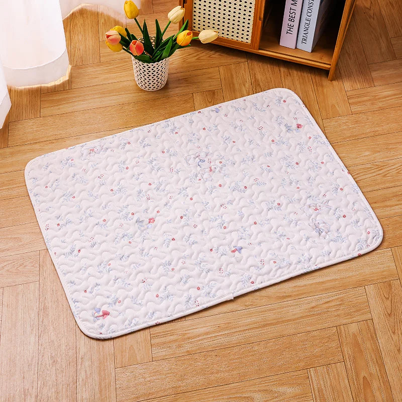 A white soft cotton pet cage mat with a non-slip base placed on a light wood floor.