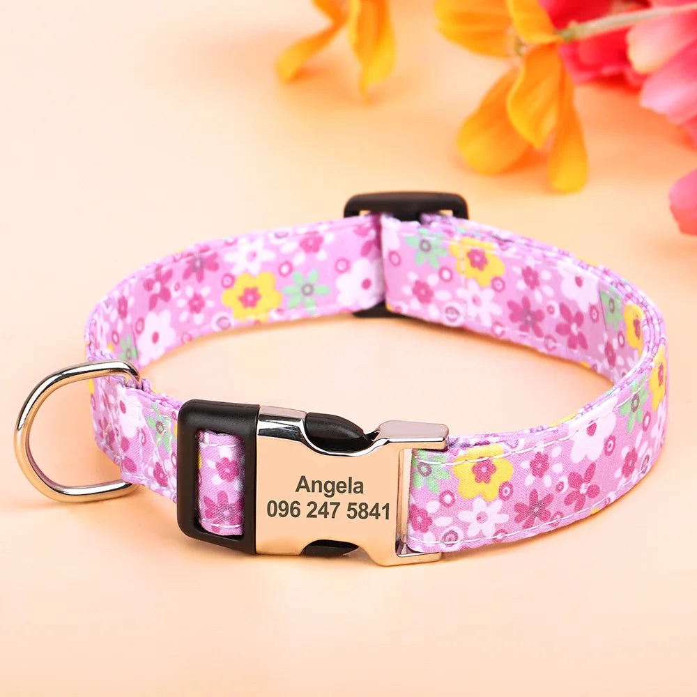 A pink floral print dog collar with a black buckle and an engraved metal name tag.