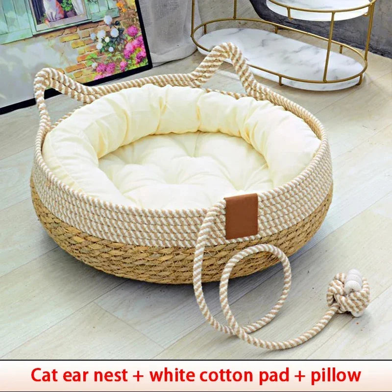 A woven rattan cat ear nest with a white cotton pad and pillow resting on a light wooden floor.