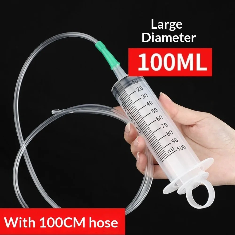 Eine Hand hält eine große Kolben-Spritze mit 100ml Fassungsvermögen und einer 100cm langen Schlauchleitung zur Ölextraktion.