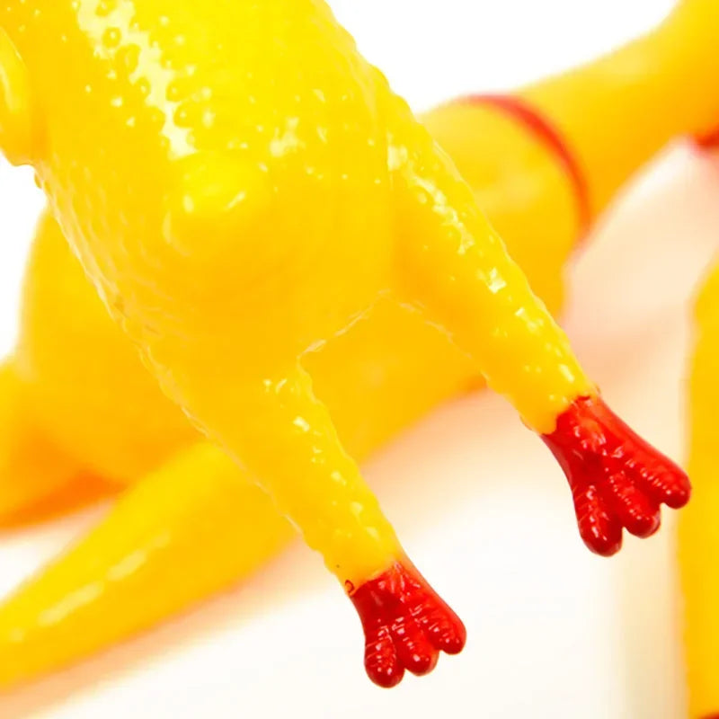 Close-up of a bright yellow rubber chicken squeaky dog toy with red feet.