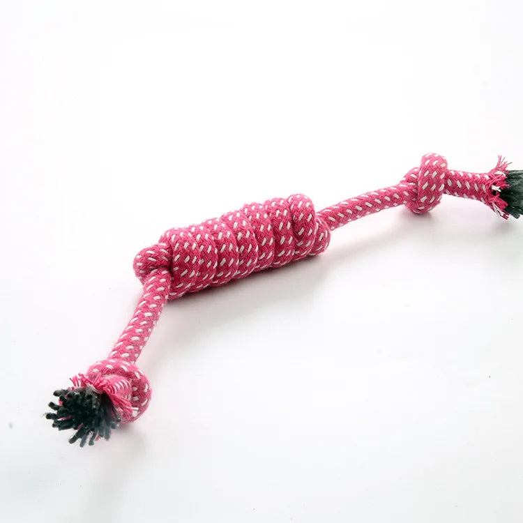 A braided red cotton rope chew toy with green tassels for dogs.