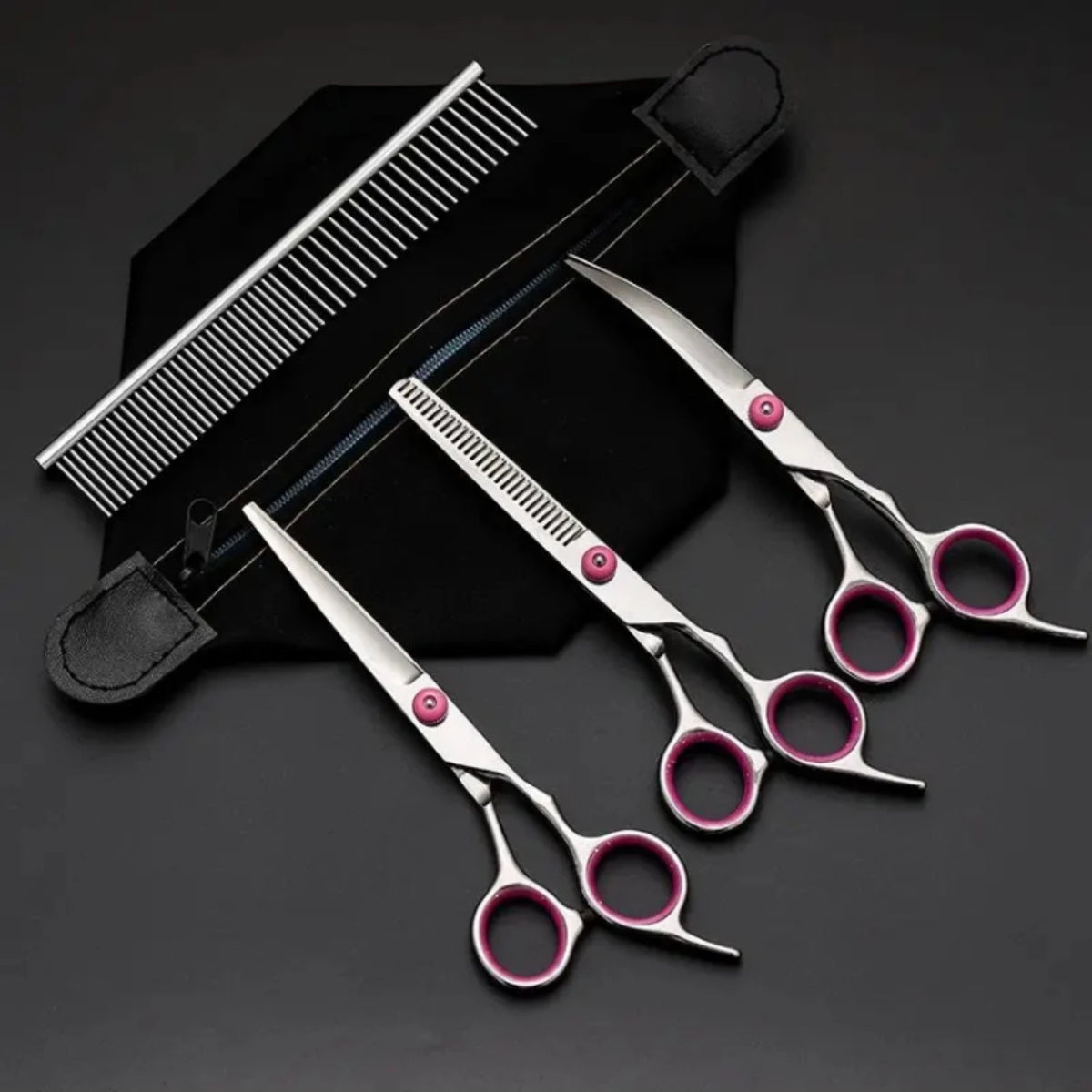 A set of grooming scissors and a comb are displayed on a black background.