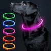 A black dog wearing a glowing LED collar with multiple color options, including green, blue, pink, and orange.