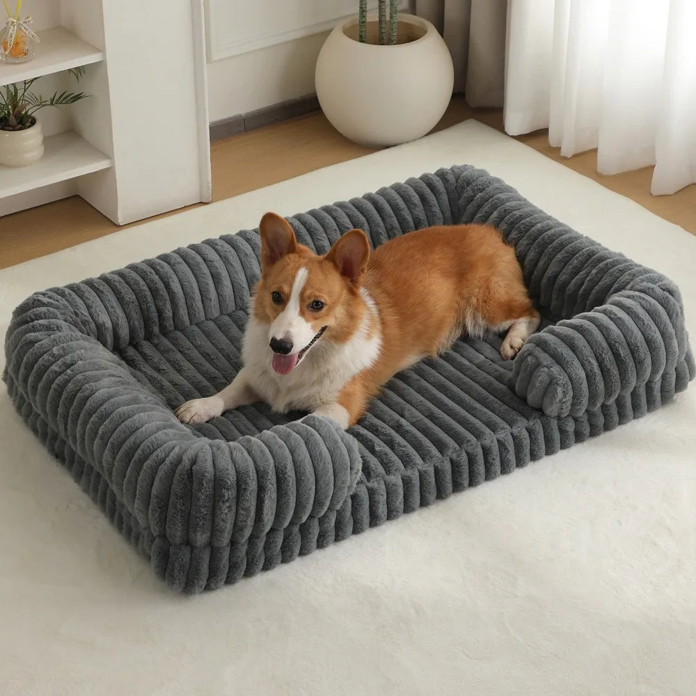Ein flauschiger orange und weißer Hund liegt auf einem grauen gerippten Hundebett auf einem weißen Teppich.