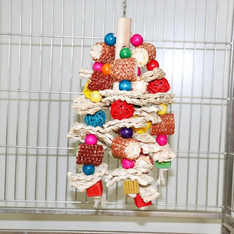 A natural wooden parrot bite toy made of various colorful, textured food items hanging in a wire cage.