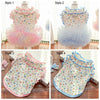 Four styles of floral vest apparel for dogs and cats shown in different colors and designs