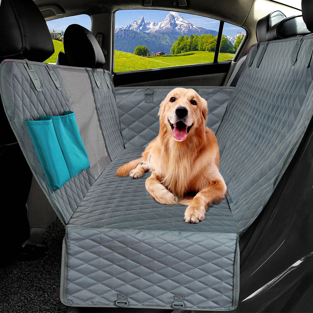 A golden retriever sits on a gray waterproof dog car seat cover with a hammock and mesh window in a car interior.