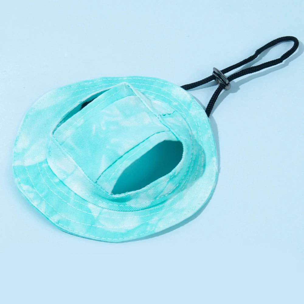 Chapeau de soleil pour chien tie-dye bleu clair et blanc avec découpes d'oreilles noires et sangle noire.