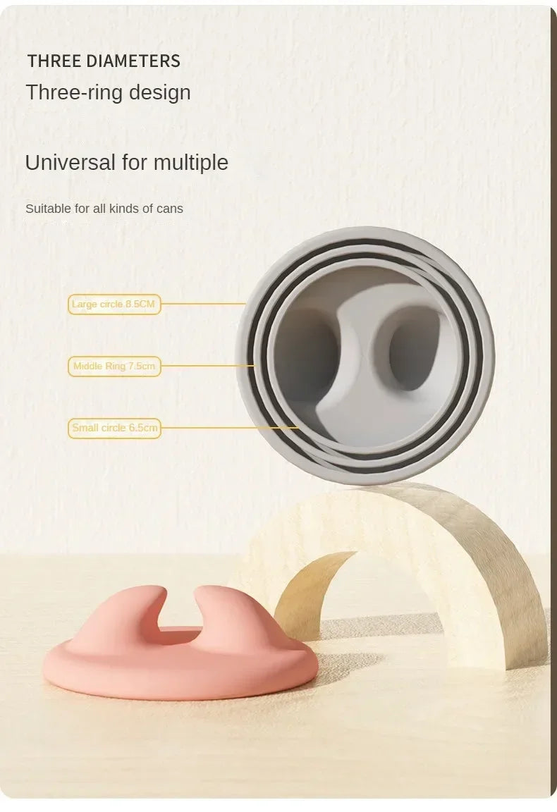 A close-up view of a three-ring design tool for cans, showing different sized rings and a pink feeding spoon component.