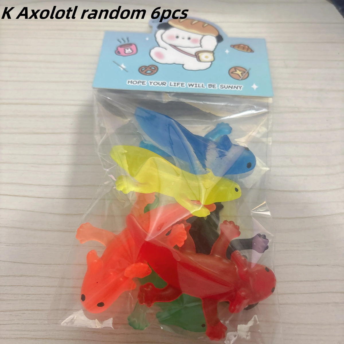A clear plastic bag contains six colorful rubber goldfish bath toys, including blue, yellow, orange, and red varieties.