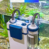 A white wall-mounted aquarium filter with blue accents is visible inside a glass tank filled with aquatic plants and stones.