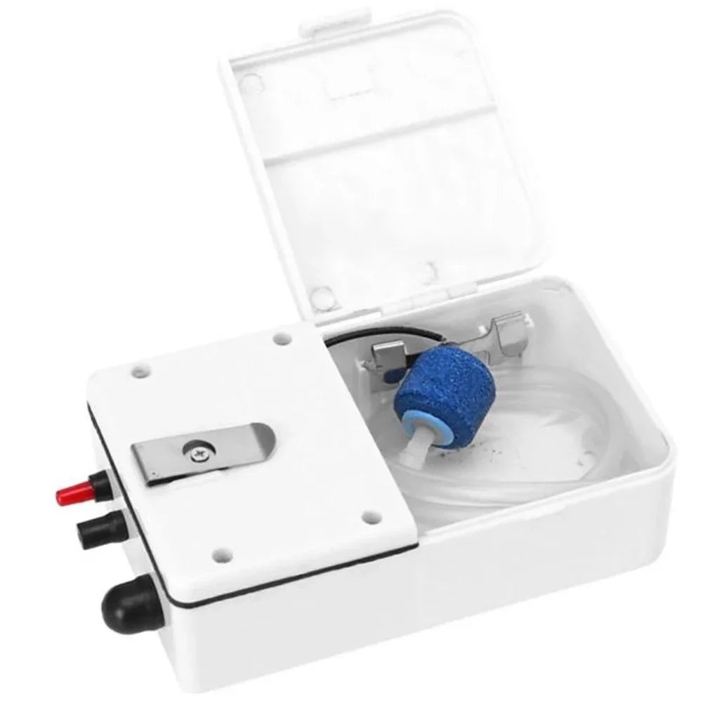 A white portable aquarium air pump with an open lid and a blue silicone component inside.
