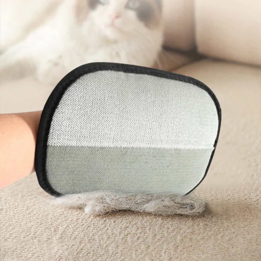 A pair of pet hair removal grooming gloves with a black and gray fabric grip resting on a beige surface.