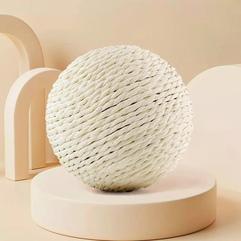 Weiße, kugelförmige Sisal-Katzenkratball auf einem hellrosa Ständer.