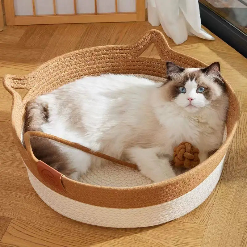 A fluffy blue and white cat is relaxing in a handwoven rattan cat bed with a cotton rope edge.