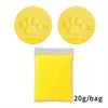 Yellow clay with paw prints and text on the top, next to a yellow plastic bag containing more clay.