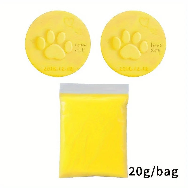 Yellow clay with paw prints and text on the top, next to a yellow plastic bag containing more clay.