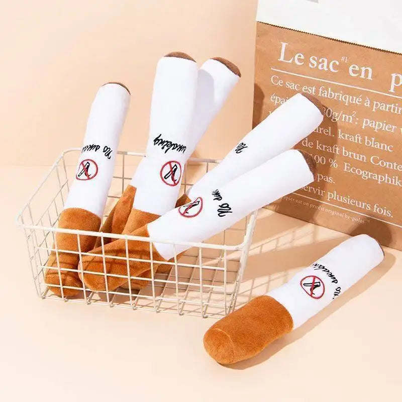 A basket filled with white, cigar-shaped squeak toys for dogs, displayed next to a brown paper bag.