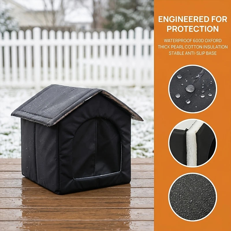 A black waterproof insulated cat house with a slanted roof sits on a wooden surface.