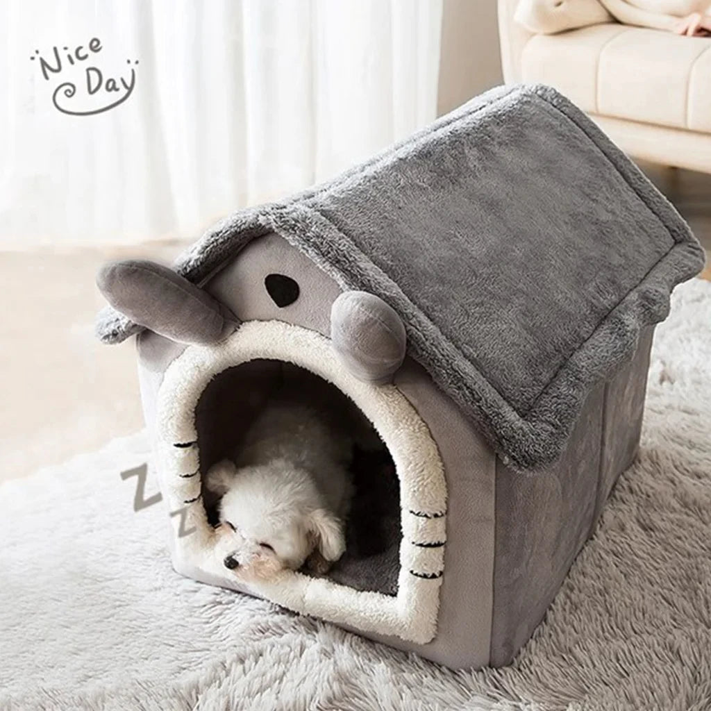 A gray foldable pet kennel shaped like a house with an arched entrance, containing a small white puppy.