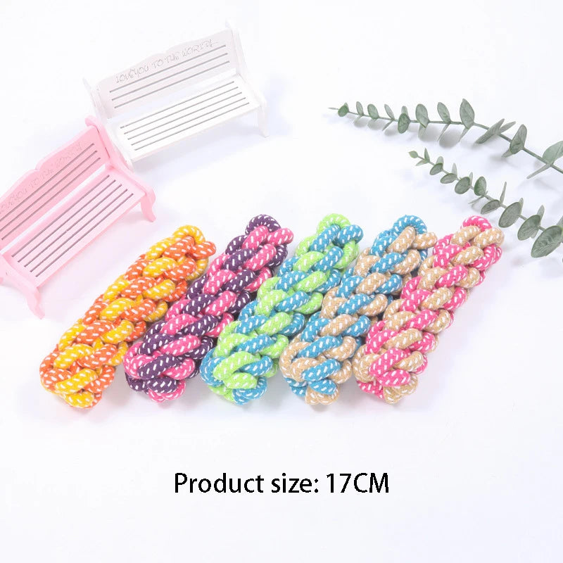 A set of colorful hemp rope chew toys for dogs, including a pink and white comb-like toy and several braided ropes.