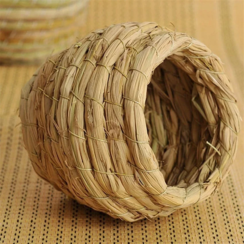 Handwoven straw bird nest for small birds with a natural woven texture.