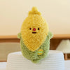 A yellow plush vegetable doll resembling a peanut, sitting on a white textured surface.