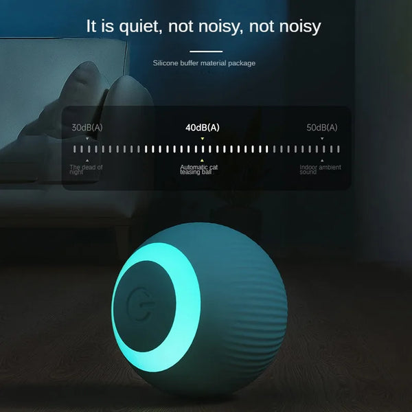 A teal spherical cat toy ball is shown on a wooden surface with a blurred background showing sound level indicators.