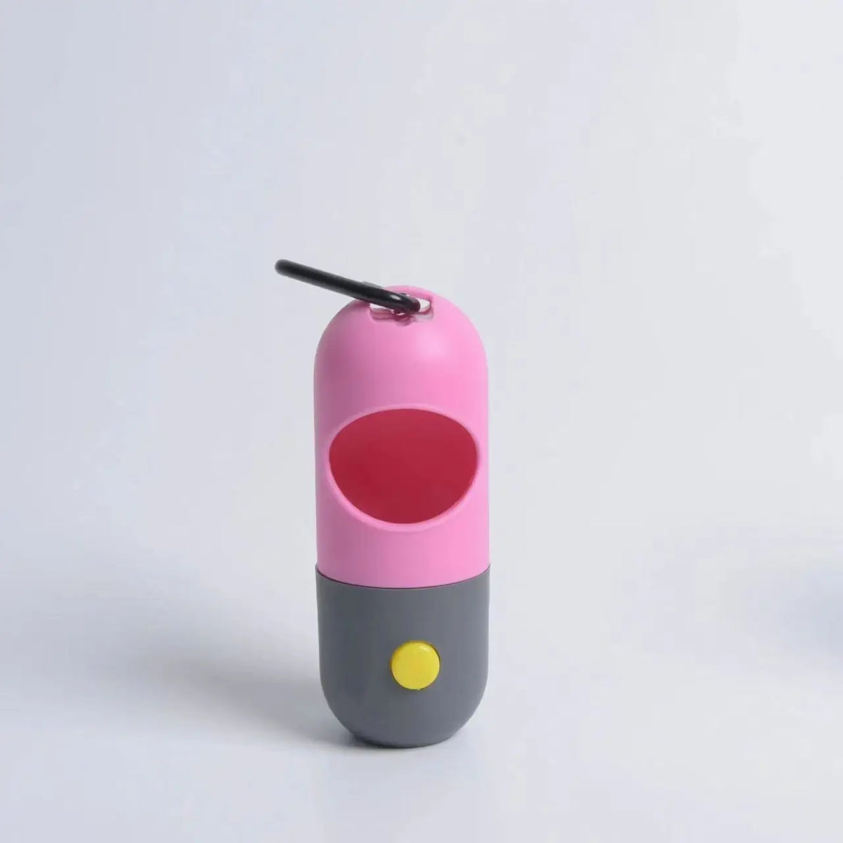 A pink and gray capsule dog waste bag dispenser with a black handle and a yellow light.