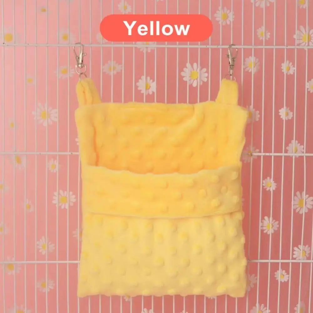 A yellow cozy hanging sleeping bag for small pets is displayed against a pink striped background.