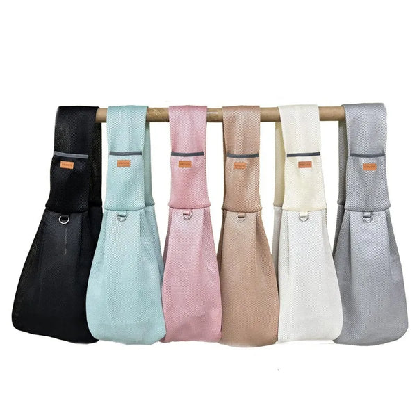 A row of five breathable mesh dog carrier crossbody bags hanging on a wooden bar.