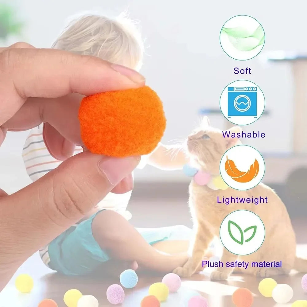 A hand is holding an orange soft plush ball toy for a cat, demonstrating its lightweight and washable features.