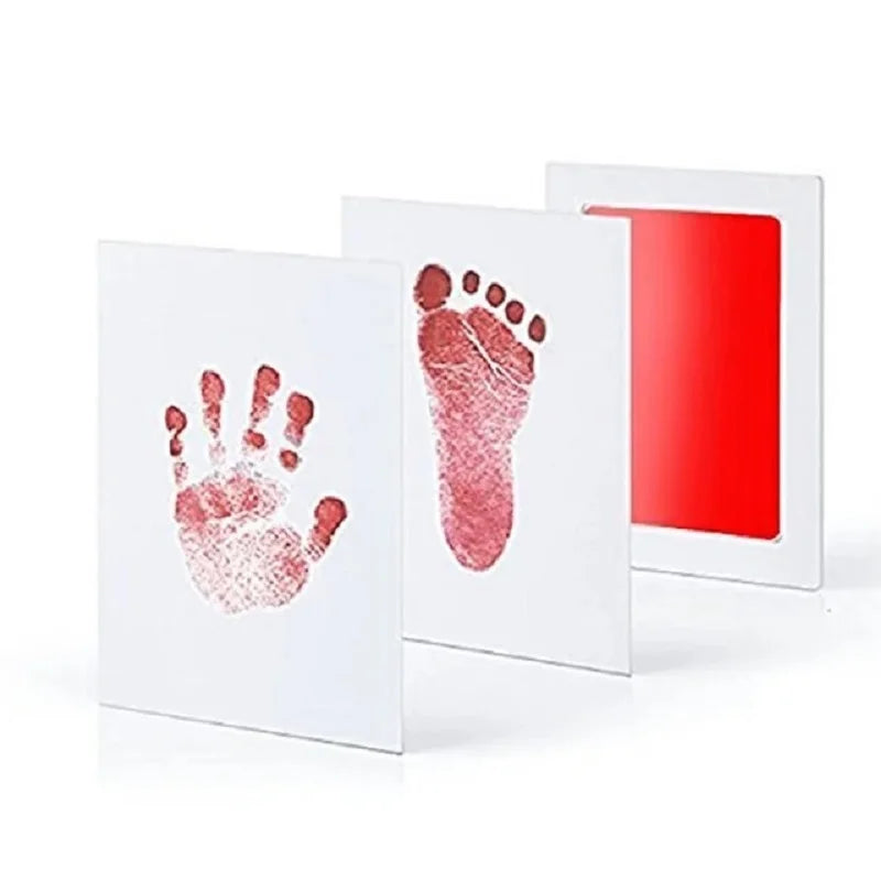Un ensemble d'estampes d'art blanches avec une empreinte de main et de pied rouge-rose sur fond blanc, affiché à côté d'un co