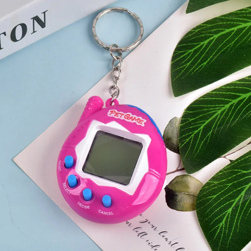 A pink digital pet toy with a clear screen and buttons is displayed on a white card next to green leaves.