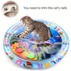 Eine tabby-Kitten liegt auf einer blauen sensorischen Matte mit bunten Plastikspielzeugen, die Nagelhautpflege benötigen.
