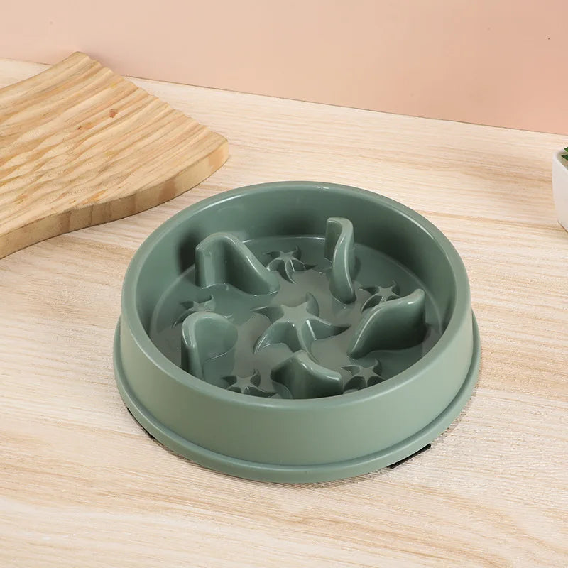 A light green anti-slip slow feeder bowl for small dogs and cats resting on a wooden surface.