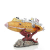 A model of a yellow submarine with a reddish creature emerging from a rock base.