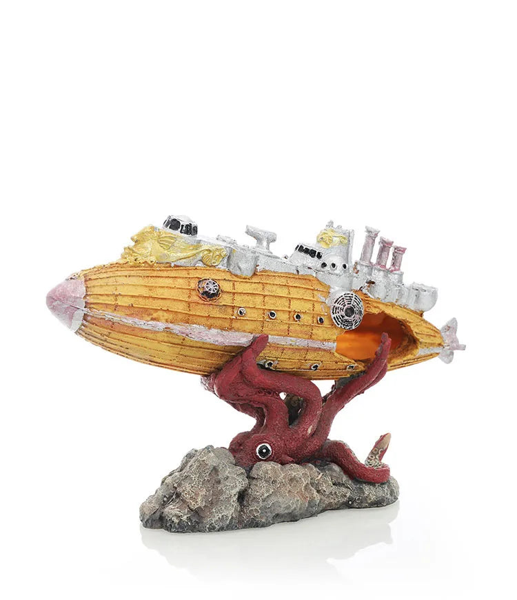 A model of a yellow submarine with a reddish creature emerging from a rock base.