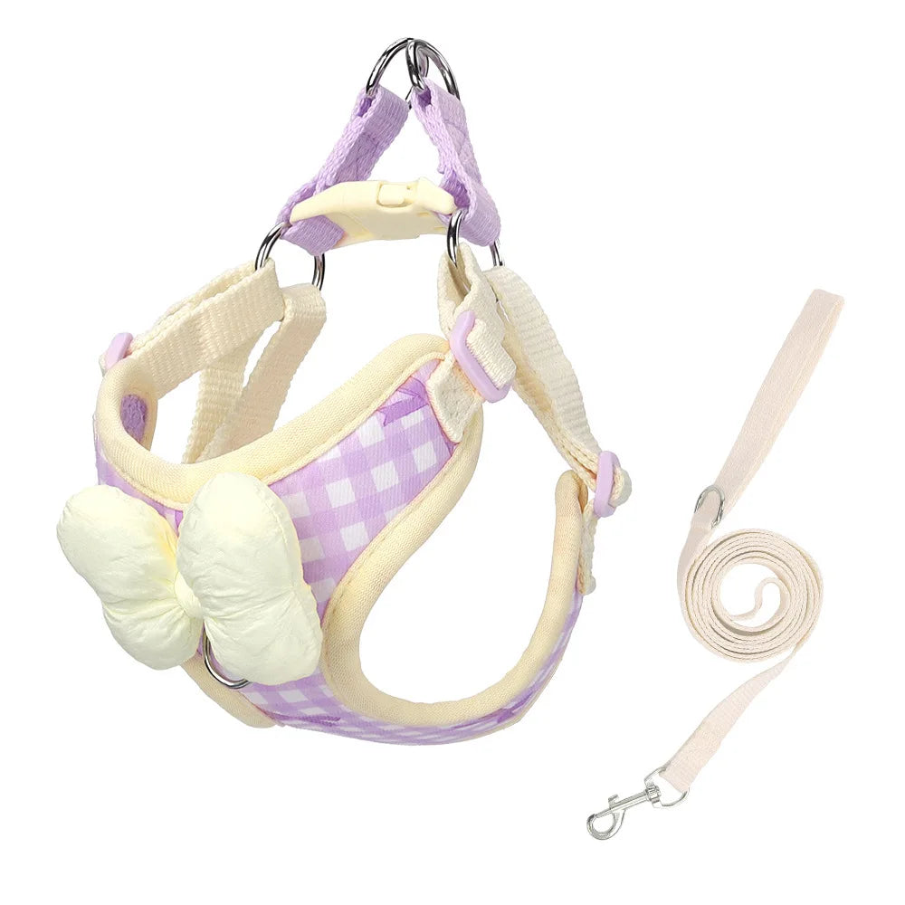 A purple and white plaid dog harness with a bow for small breeds, shown against a white background.