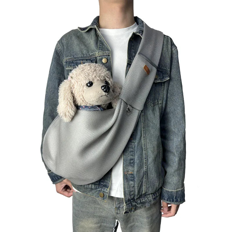 A person wearing a denim jacket and white shirt with a breathable mesh dog carrier crossbody bag.