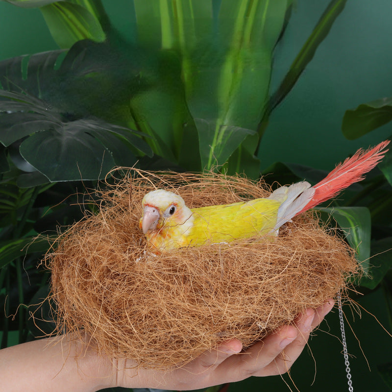 A hand holds a nest made of natural coconut fiber bird bedding.
