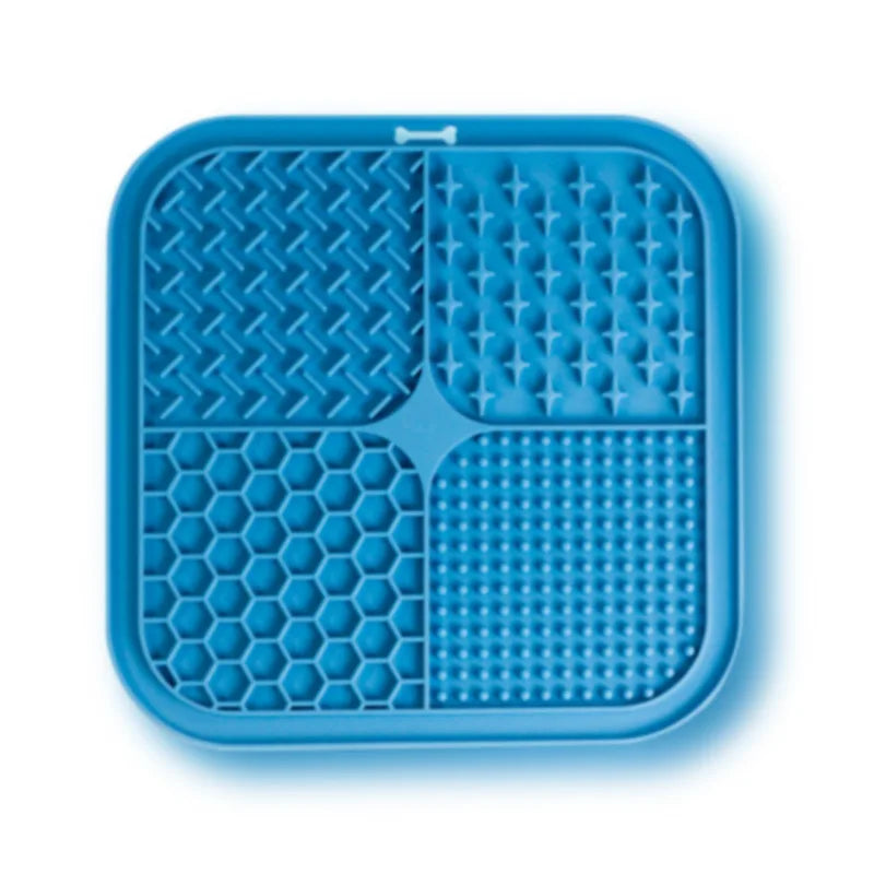 A blue silicone pet licking mat with suction cups divided into four sections for slow feeding