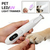 Eine Hand hält einen weißen Haartrimmer mit LED/UV-Licht und demonstriert dessen Verwendung an einem Hundefuß.