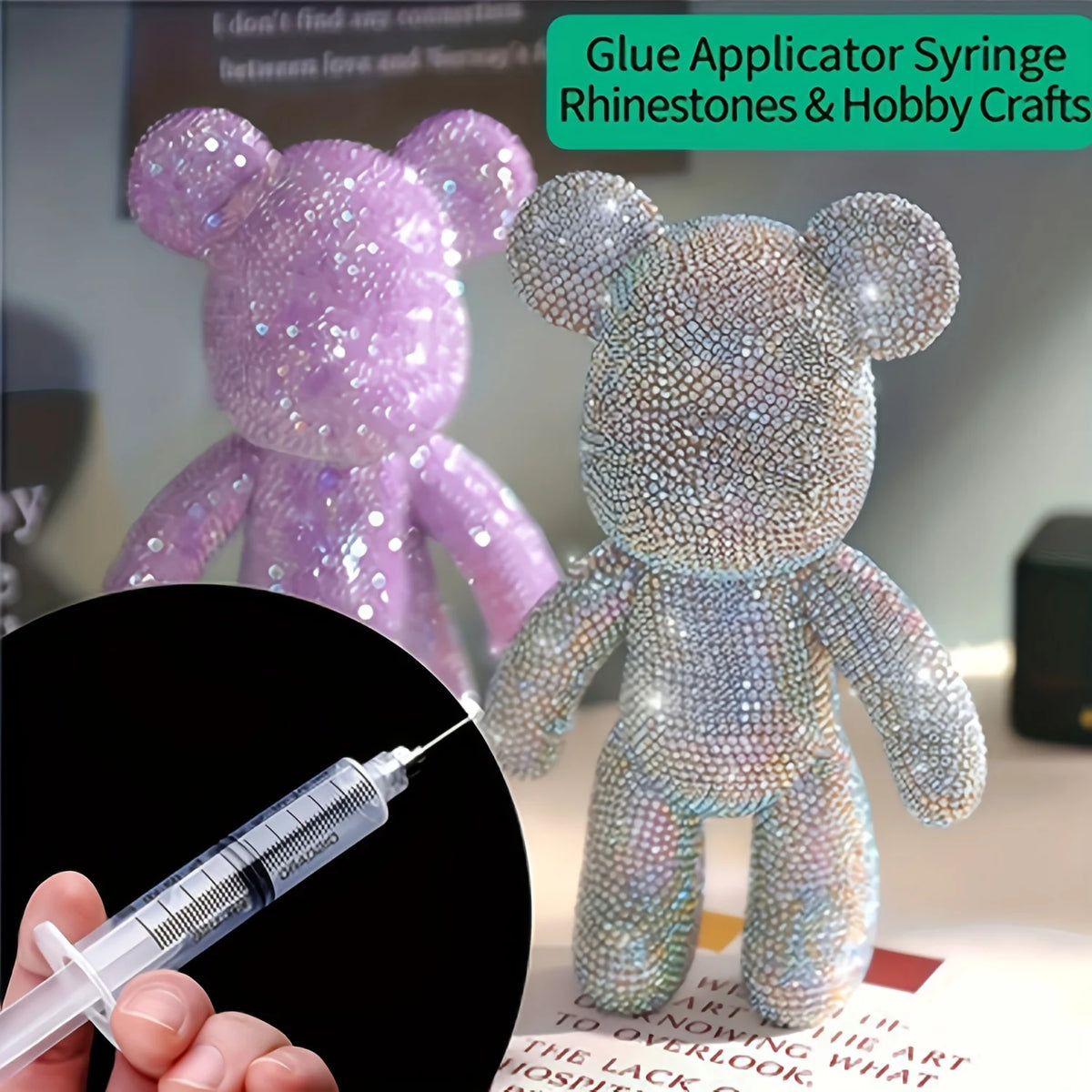 A hand holds a syringe with glitter glue applicator tip next to a purple and blue rhinestone teddy bear craft kit.