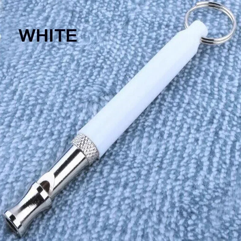 A white ultrasonic dog training whistle with a silver tip is shown against a blue textured background.