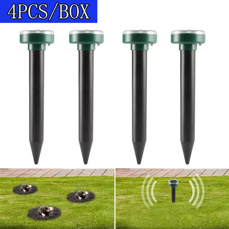 Four black solar ultrasonic pest repellers inserted into the ground on a green lawn.