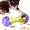 Un gatito interactuando con una pelota juguete para alimentador de mascotas de plástico morado y verde, visibles pellets de c