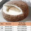 A round, brown faux fur pet bed with white trim shown on a light gray surface.