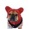 Primer plano de un gorro de lana rojo para perros de invierno con diseño de cara de pug.